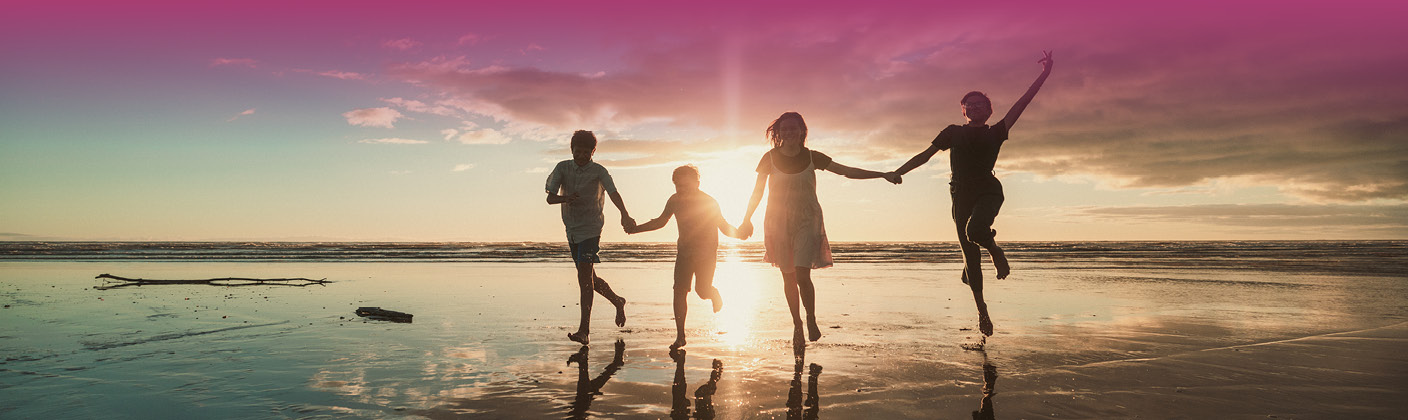 An image of four happy children playing on the beach